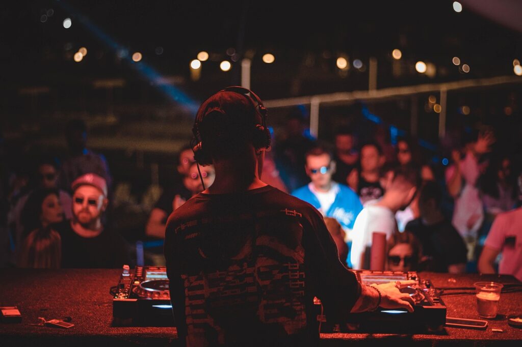 DJ am Mischpult bei einer Veranstaltung mit farbigem Licht